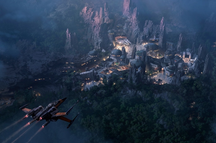 Star Wars X-wing flies over a settlement in mountains
