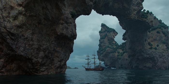 4K boat sailing through rock archway