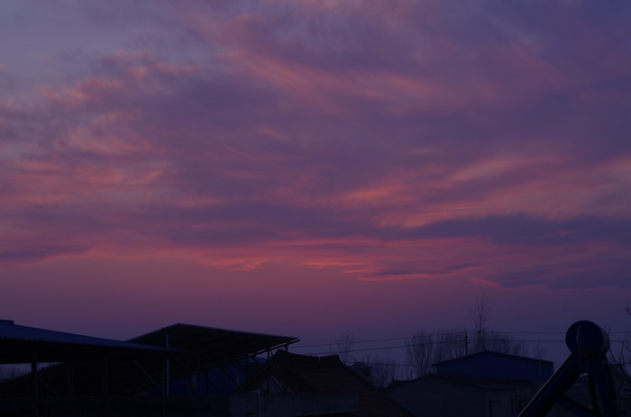 Purple and pink clouds at dusk over buildings