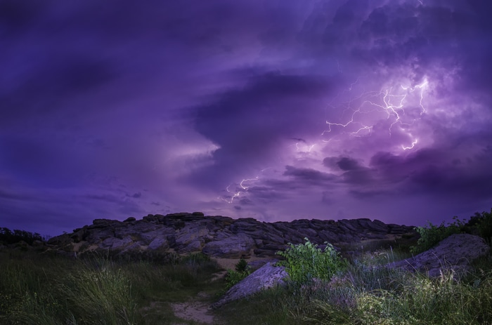 Thunderstorm with lightning over rocky terrain