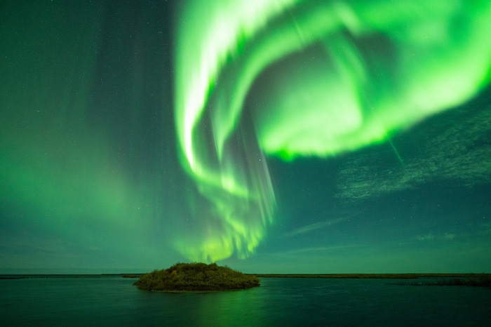 Aurora Borealis over a small island in water