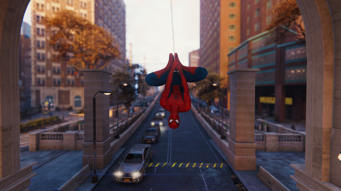 Spider-Man hanging upside down over a street