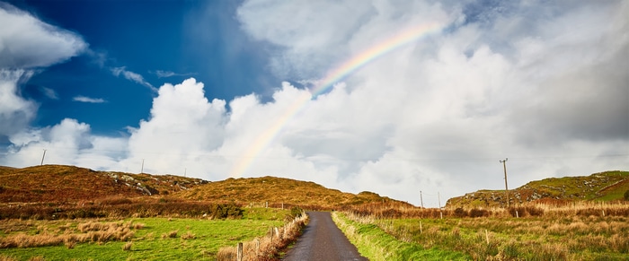 4K road with rainbow and clouds