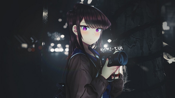 Komi-san holding a camera at night