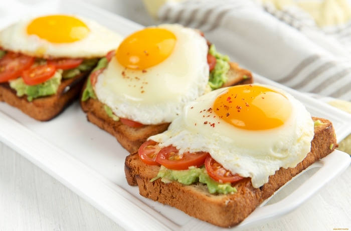 Avocado toast with fried eggs and tomatoes
