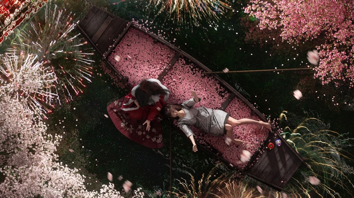 Two women in a boat filled with flower petals