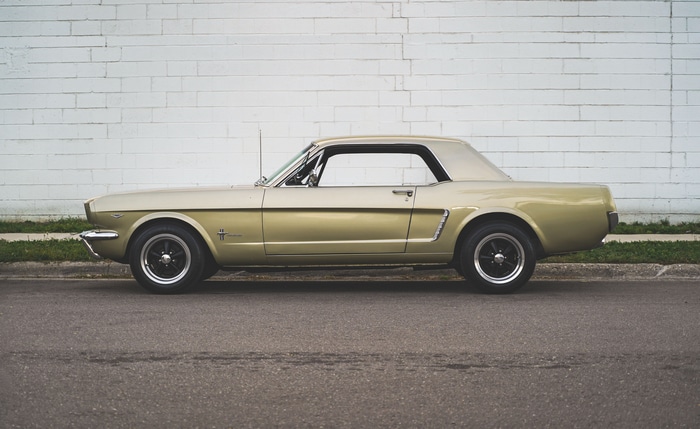 1967 Ford Mustang parked by a white brick wall