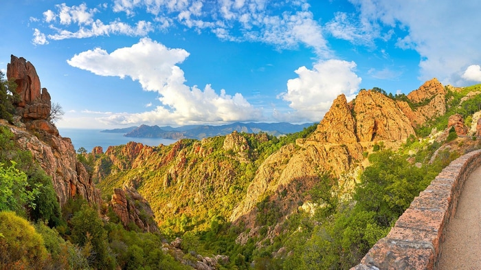 Rocky mountains and sea under a blue sky with clouds