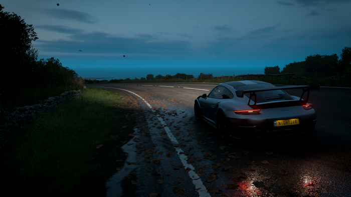 Porsche 911 GT2 RS on a wet road at dusk