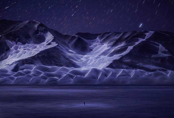 Snowy mountains under starry night sky in China