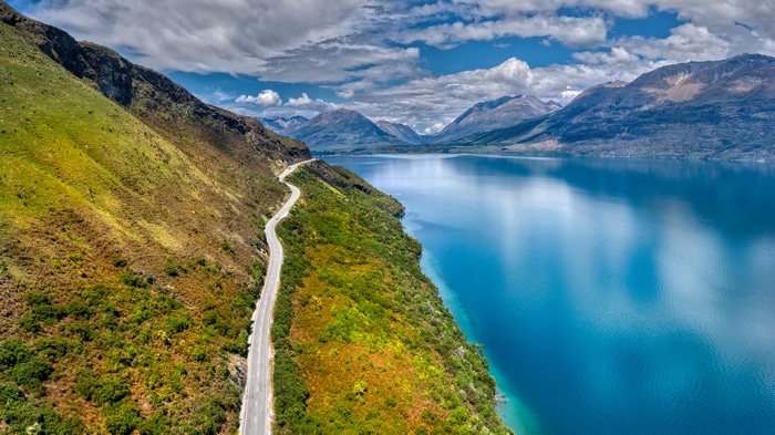 4K Landscape of a Winding Road by a Lake and Mountains