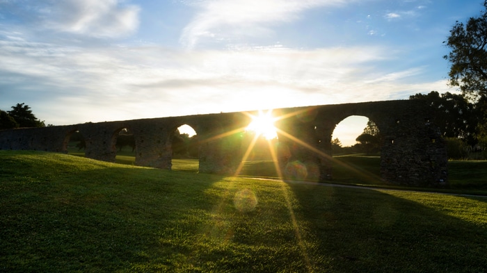 Old stone aqueduct in Lisbon at sunset