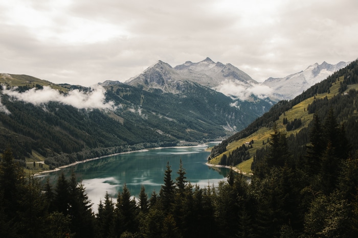 Mountains and lake landscape with forest and clouds