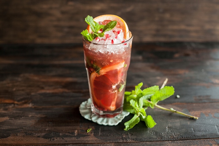 Grapefruit and mint cocktail with ice and pomegranate seeds