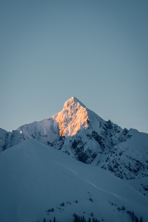 Snowy mountain top illuminated by sunlight