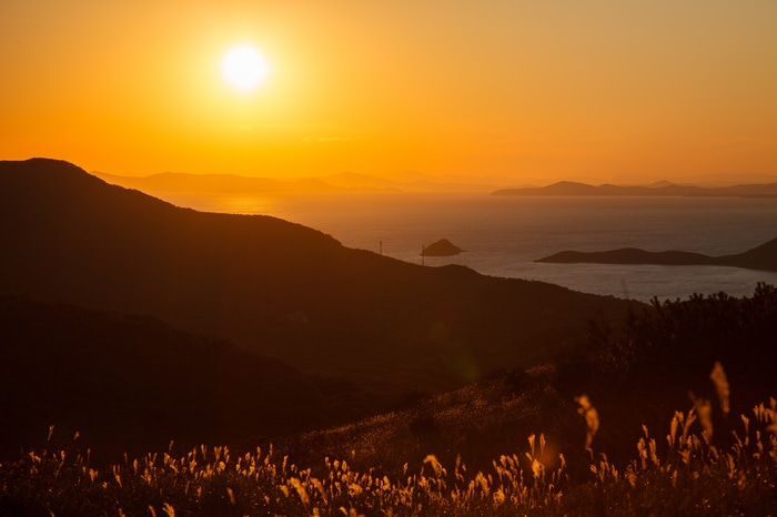 Sunset over the ocean with islands and mountains