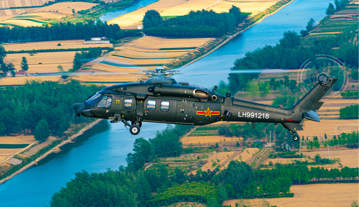 Chinese Z-20 helicopter flying over farmland