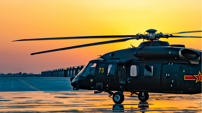 Chinese Z-20 helicopter on tarmac at sunset