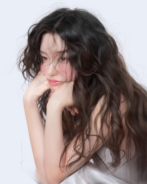 Asian woman with long dark curly hair resting her face on her hands