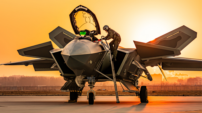 PLAAF pilot climbing into a fighter jet at sunset