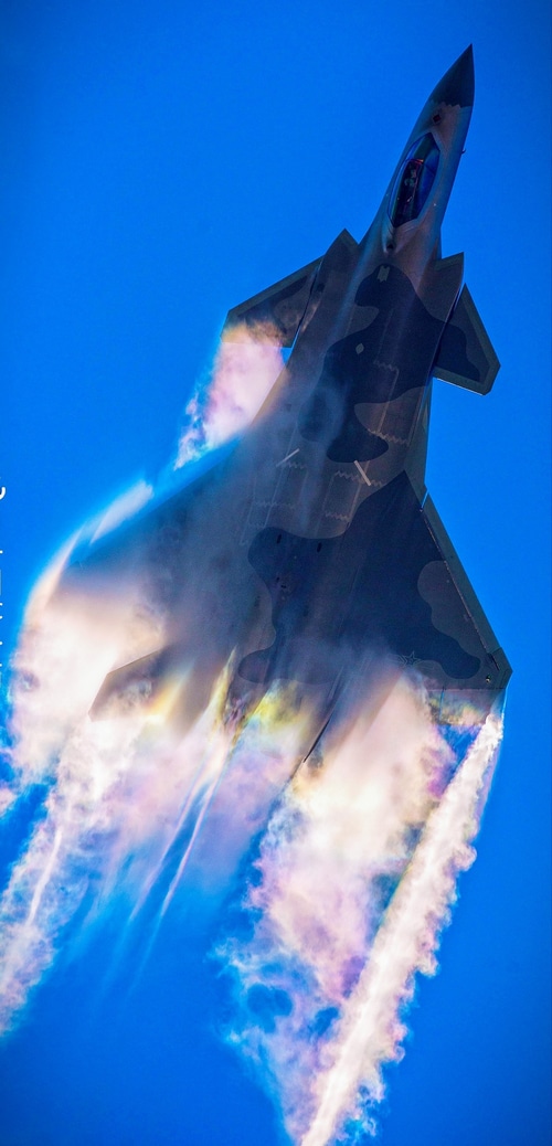 Chengdu J-20 fighter jet with colorful contrails