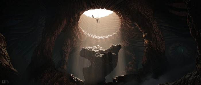 Person rappelling down into a massive cave