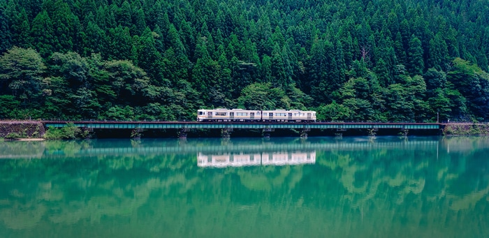 Train crossing a bridge over a lake in Japan