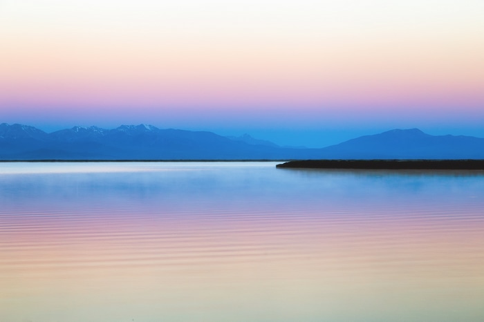 Calm water and mountains at sunrise
