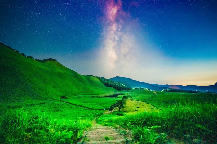 Milky Way over green hills in Japan at night