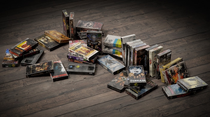 Collection of VHS tapes on a wooden floor