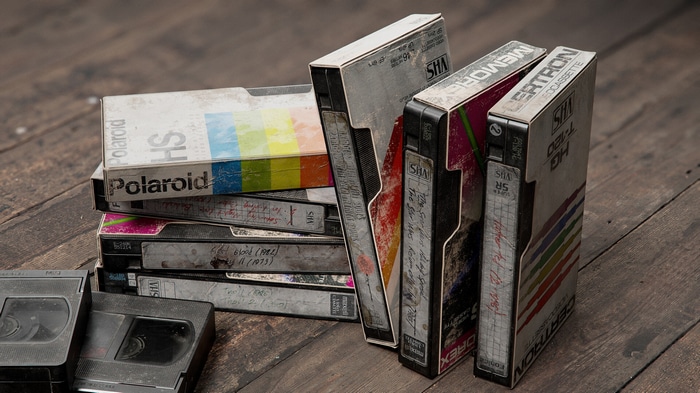 Stack of old VHS tapes on wooden surface