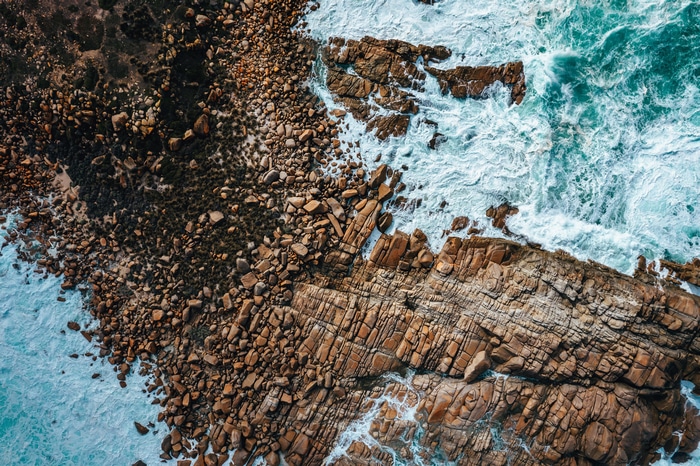 Aerial view of rocky coastline with crashing waves