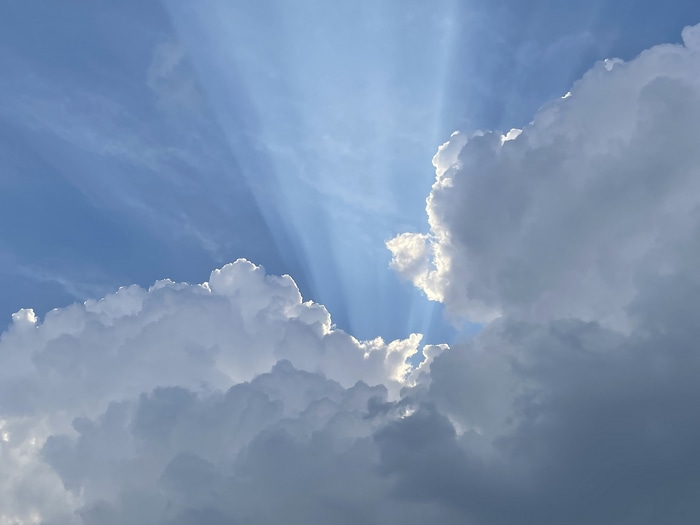 4K sunlight rays through clouds in blue sky