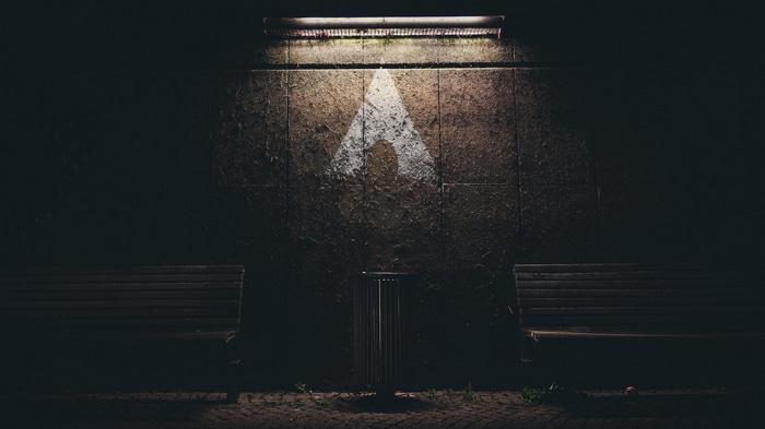 Arch Linux logo projected on a wall at night
