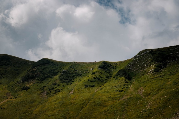 Green mountain range under cloudy sky in Russia