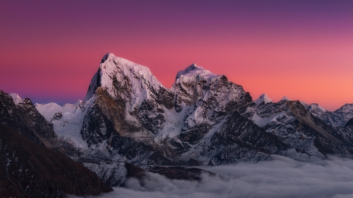 Snow-capped mountains under a vibrant sunset sky