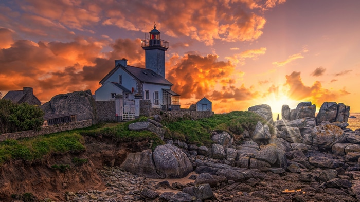 4K sunset over lighthouse on rocky coast of France