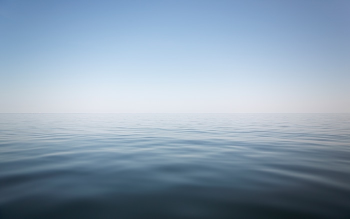 Minimalist seascape with calm water and clear sky