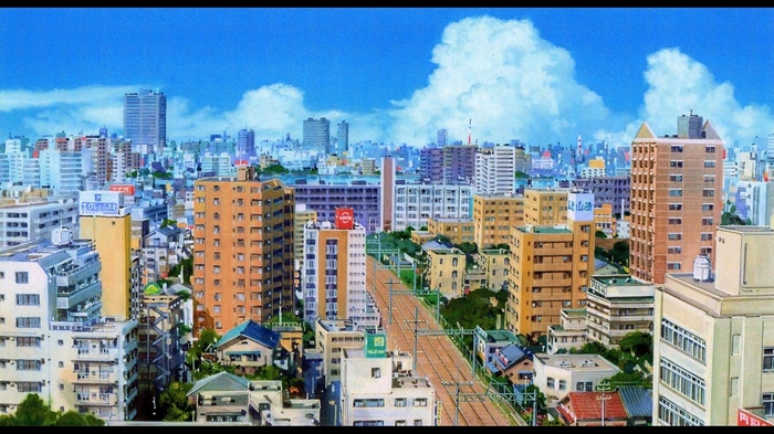 Cityscape of buildings and train tracks under a blue sky