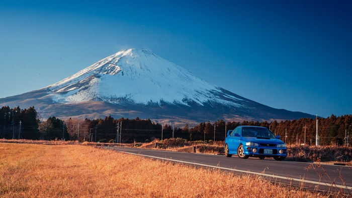 Blue Subaru Impreza driving towards Mount Fuji, Japan