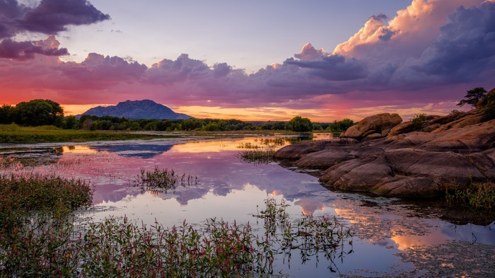 Sunset over a lake with mountains and rocks