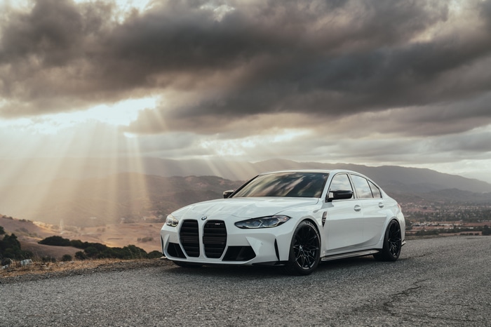 4K white BMW M3 G80 on asphalt road