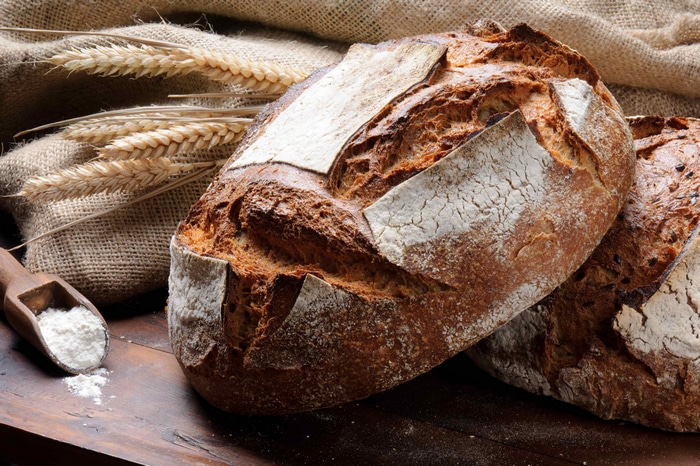 4K bread with wheat and flour on a table