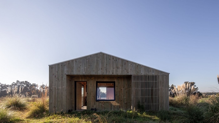 Wooden house facade in a grassy field