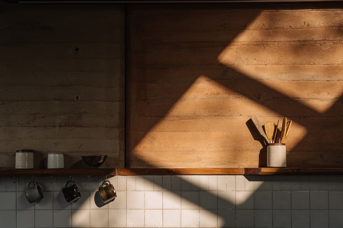 Kitchen shelf with mugs and utensils in sunlight
