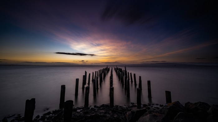 Long exposure of old pier pilings at sunset