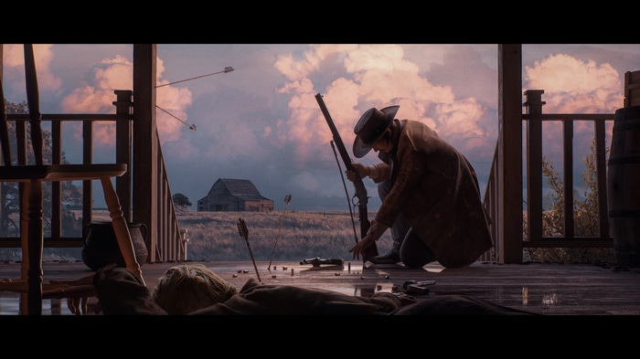 Cowboy on a porch with a rifle and dead body