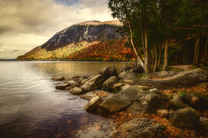 Autumn mountain lake with rocky shore and trees