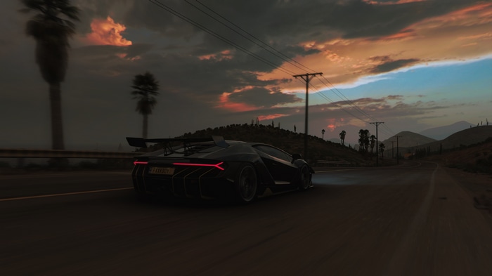 Lamborghini driving on a road at sunset
