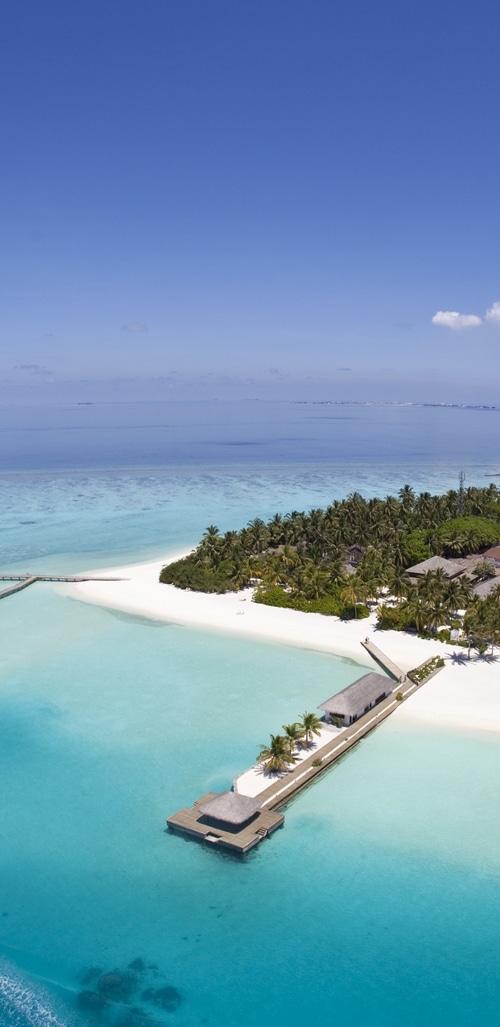 Aerial view of a tropical island with palm trees and a pier